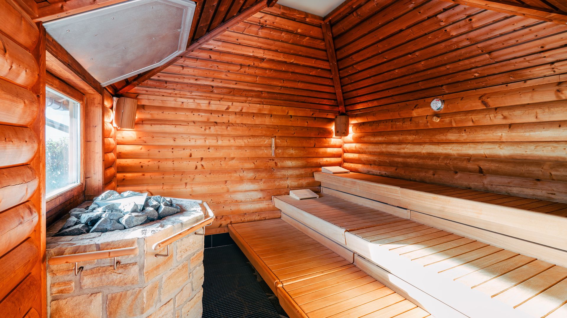 Ilo-Sauna von innen mit Steinofen und drei Bänken.
