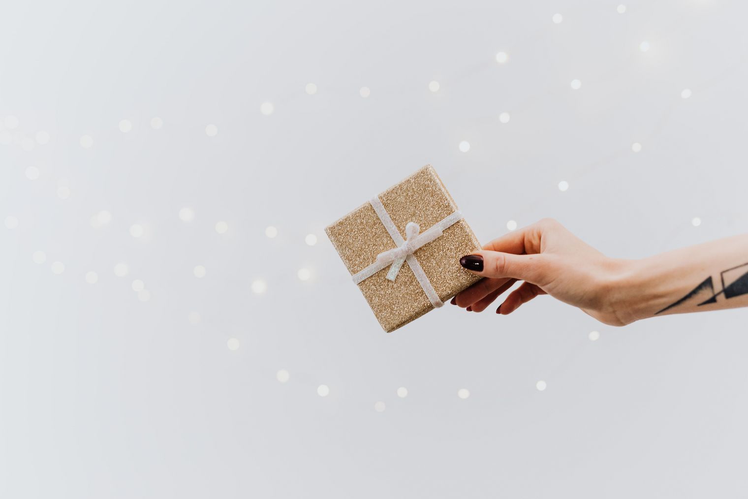 Eine Hand hält ein kleines eingepacktes Geschenk